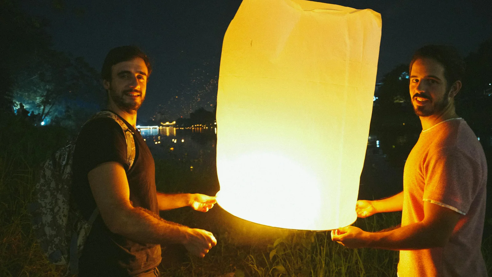 People holding a glowing lantern during a Chiang Mai lantern festival